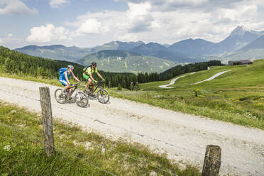 Couple mountainbiking on gravel path in the mountains, Achenkirch, Austria - SDAHF00817