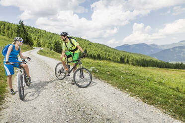 Mountainbike-Paar auf Schotterweg in den Bergen, Achenkirch, Österreich - SDAHF00822