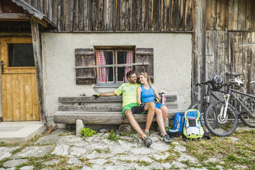 Ehepaar mit Mountainbikes bei einer Pause auf einer Berghütte, Achenkirch, Österreich - SDAHF00838