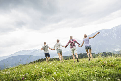 Friends running on a meadow in the mountains, Achenkirch, Austria - SDAHF00839