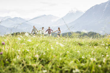 Friends running on a meadow in the mountains, Achenkirch, Austria - SDAHF00840