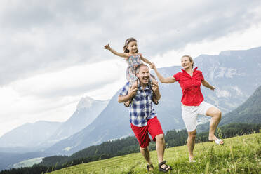 Happy family running on a meadow in the mountains, Achenkirch, Austria - SDAHF00841