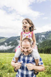 Happy father carrying daughter on shoulders on a meadow in the mountains, Achenkirch, Austria - SDAHF00844