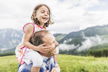 Glücklicher Vater, der seine Tochter auf den Schultern trägt, auf einer Wiese in den Bergen, Achenkirch, Österreich - SDAHF00845
