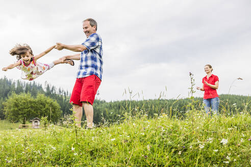 Vater spielt mit glücklicher Tochter auf einer Wiese in den Bergen, Achenkirch, Österreich - SDAHF00846