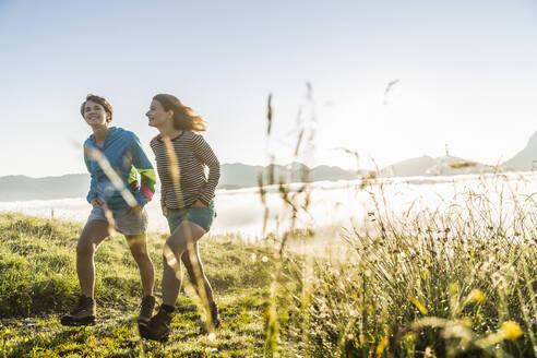 Two female friends hiking on a meadow in the mountains, Achenkirch, Austria - SDAHF00848