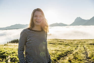 Porträt einer glücklichen Frau auf einer Wiese in den Bergen, Achenkirch, Österreich - SDAHF00849