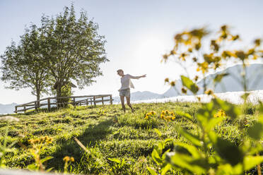 Carefree woman dancing on a meadow in the mountains, Achenkirch, Austria - SDAHF00858