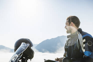 Motorcyclist on a trip having a break in the mountains, Achenkirch, Austria - SDAHF00861