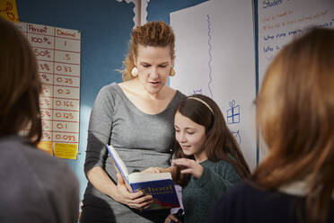 Mädchen und Lehrer in einer Klasse während einer Unterrichtsstunde - PWF00062