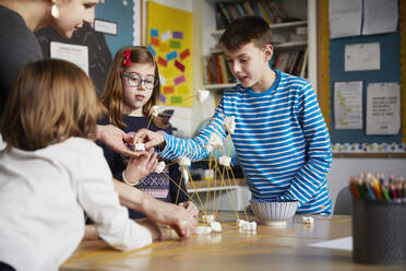 Drei Kinder und ein Lehrer während einer naturwissenschaftlichen Unterrichtsstunde - PWF00097