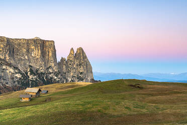 Autumn sunrise over Sciliar peaks and wood huts at Alpe di Siusi (Seiser Alm), Dolomites, South Tyrol, Italy, Europe - RHPLF14611