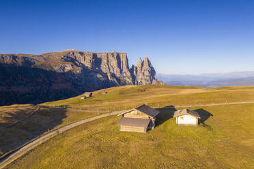 Luftaufnahme einer Drohne vom Sonnenaufgang auf der Seiser Alm und dem Schlern im Herbst, Dolomiten, Südtirol, Italien, Europa - RHPLF14612