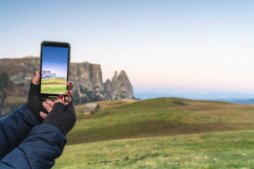 Persönliche Perspektive einer Frau beim Fotografieren von Schlerngipfeln mit Smartphone, Seiser Alm, Dolomiten, Südtirol, Italien, Europa - RHPLF14613