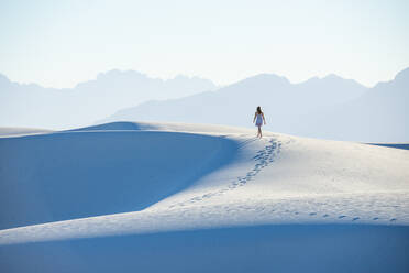 A woman walking along a dune's ridge in White Sands National Park, New Mexico, United States of America, North America - RHPLF14634