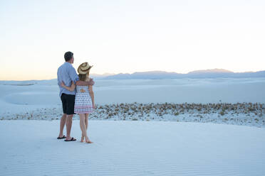 A couple enjoy White Sands National Park at sunset, New Mexico, United States of America, North America - RHPLF14636