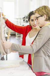 Fashion designers discussing in a tailor shop - SDAHF00895