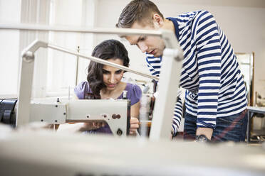 Young man and seamstress at work in a tailor shop - SDAHF00916