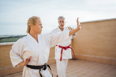 Frau mit Lehrer beim Karatetraining auf der Terrasse - OCMF01203