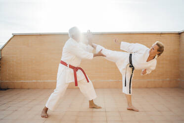 Frau mit Lehrer beim Karatetraining auf der Terrasse - OCMF01206