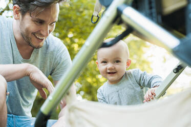 Portrait of laughing baby girl with her father in a park - DIGF10249