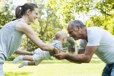 Älterer Mann verbringt Zeit mit seiner erwachsenen Tochter und seiner Enkelin in einem Park - DIGF10255