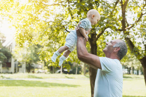 Senior man spending time with his granddaughter in a park stock photo