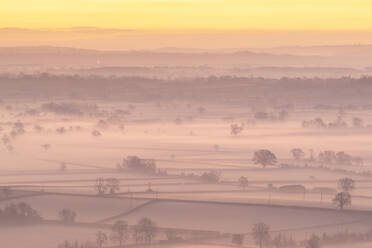 Morgendämmerung über der nebelumhüllten Landschaft der Somerset Levels im Winter, Glastonbury, Somerset, England, Vereinigtes Königreich, Europa - RHPLF14681