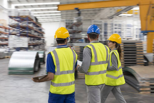 Arbeiter gehen und sprechen in einer Fabrik - CAIF27081