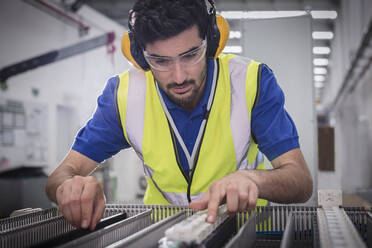 Male engineer assembling equipment in factory - CAIF27089