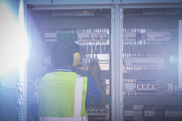 Ingenieur bei der Arbeit am Schaltpult in einer Fabrik - CAIF27119