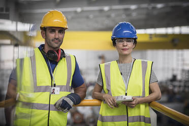 Porträt selbstbewusster Aufsichtspersonen mit digitalem Tablet auf einer Plattform in einer Fabrik - CAIF27120