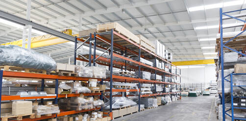 Pallets and equipment on shelves in warehouse - CAIF27160