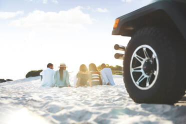 Junge Freunde entspannen sich, hängen am Strand hinter dem Jeep ab - CAIF27178