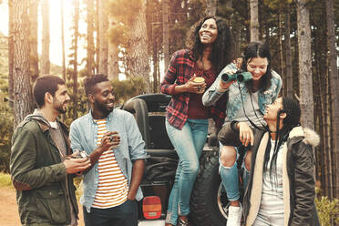 Junge Freunde hängen ab, trinken Kaffee am Jeep im Wald - CAIF27179