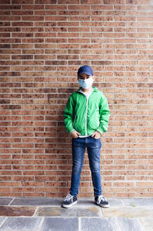 Junge mit Schutzmaske vor einer Ziegelmauer stehend - JCMF00680