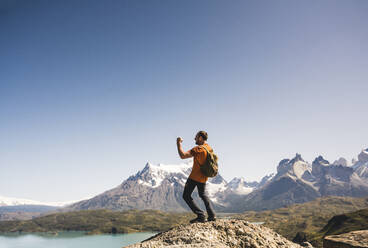 Wanderer jubelnd in der Berglandschaft am Lago Pehoe im Torres del Paine National Park, Patagonien, Chile - UUF20238