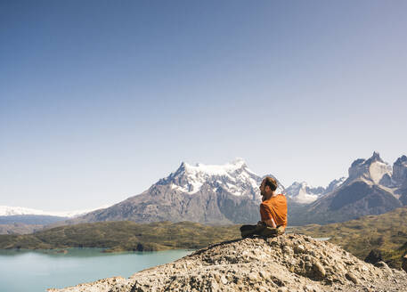 Wanderer beim Ausruhen in der Berglandschaft am Lago Pehoe im Torres del Paine National Park, Patagonien, Chile - UUF20240