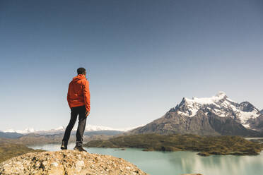 Hiker in mountainscape at Lago Pehoe in Torres del Paine National Park, Patagonia, Chile - UUF20244