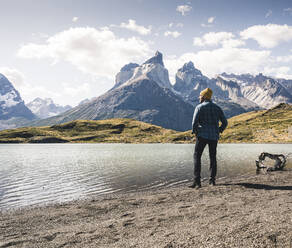 Hiker in mountainscape at lakeside in Torres del Paine National Park, Patagonia, Chile - UUF20247