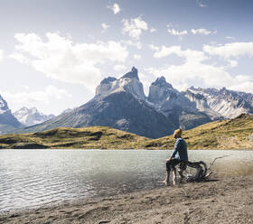 Wanderer in einer Berglandschaft, der sich in einem See im Torres del Paine National Park, Patagonien, Chile, ausruht - UUF20250