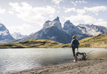 Hiker in mountainscape at lakeside in Torres del Paine National Park, Patagonia, Chile - UUF20251