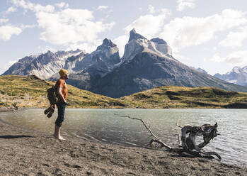 Hiker in mountainscape at lakeside in Torres del Paine National Park, Patagonia, Chile - UUF20263