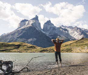 Hiker in mountainscape at lakeside in Torres del Paine National Park, Patagonia, Chile - UUF20266