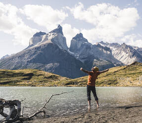 Hiker in mountainscape at lakeside in Torres del Paine National Park, Patagonia, Chile - UUF20267
