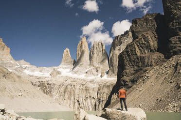 Hiker in mountainscape at lakeside at Mirador Las Torres in Torres del Paine National Park, Patagonia, Chile - UUF20268