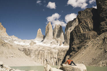 Wanderer beim Ausruhen in der Berglandschaft am Seeufer des Mirador Las Torres im Torres del Paine Nationalpark, Patagonien, Chile - UUF20269