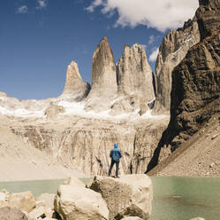 Hiker in mountainscape at lakeside at Mirador Las Torres in Torres del Paine National Park, Patagonia, Chile - UUF20271