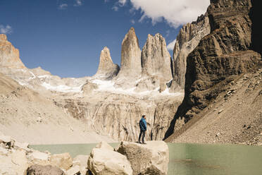 Wanderer in einer Berglandschaft am Seeufer des Mirador Las Torres im Torres del Paine National Park, Patagonien, Chile - UUF20272