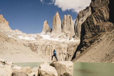 Wanderer, der am Mirador Las Torres im Torres del Paine National Park, Patagonien, Chile, in die Berglandschaft springt - UUF20273